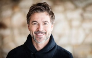 Middle-aged man in blue sweater smiling